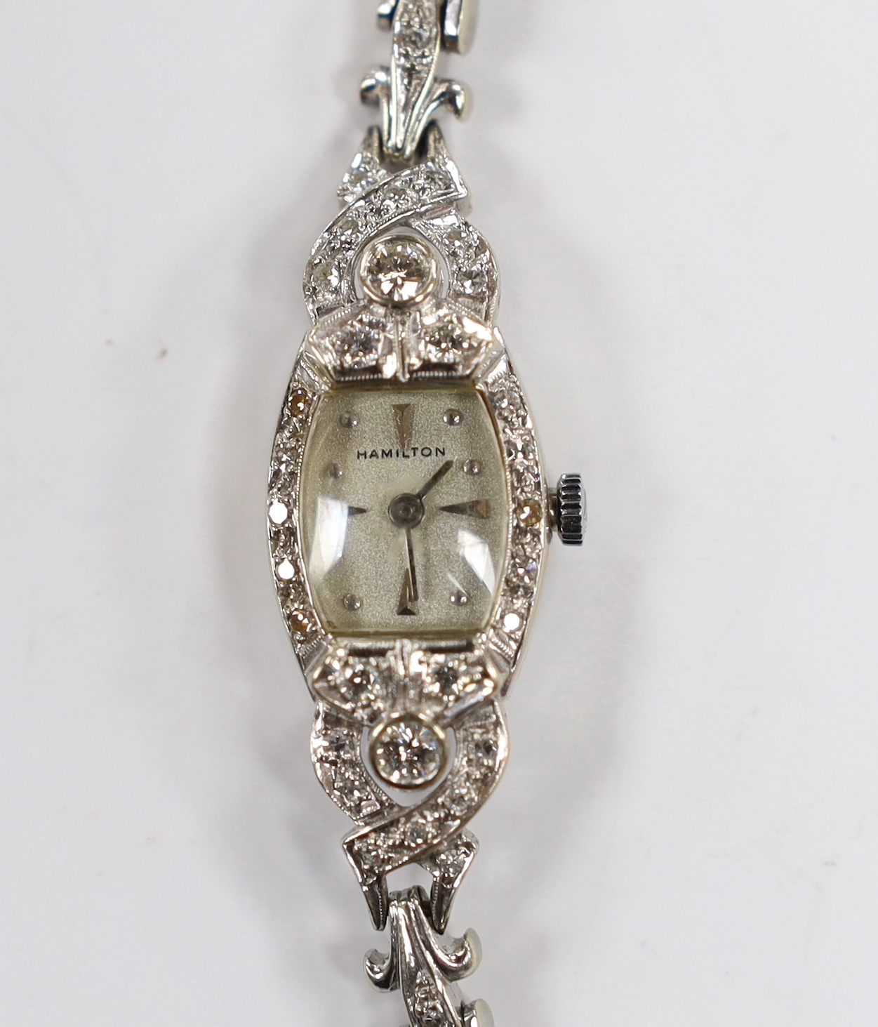 A lady's America 14k white metal and diamond cluster set manual wind cocktail watch, with diamond set bezel, lugs and bracelet, approx. 15cm, gross weight 18.9 grams, with safety chain.